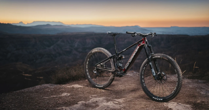 Black and burgundy Mondraker mountain bike equipped with Öhlins suspension the mountains at twilight.